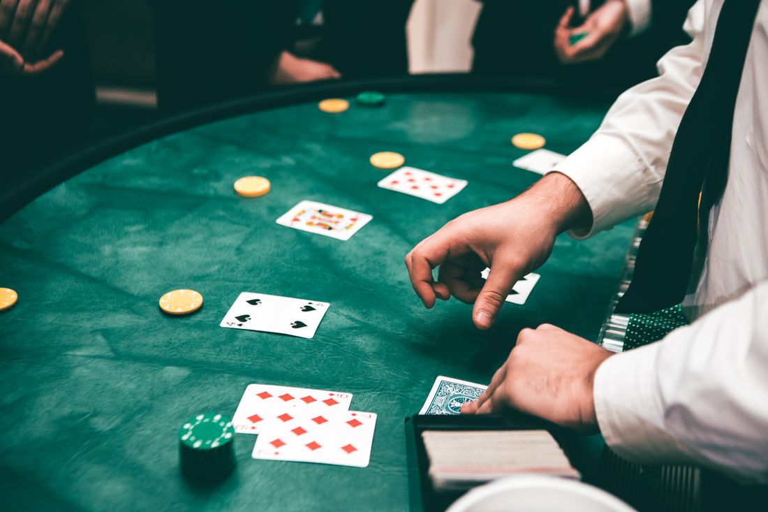 Pemain poker memegang kartu remi di meja permainan